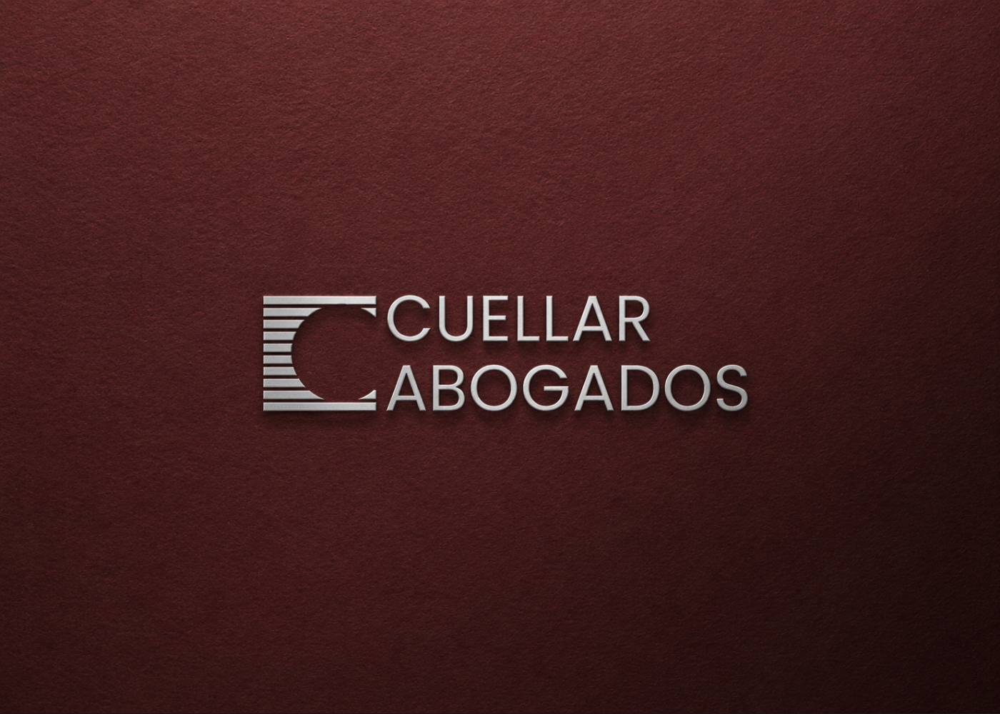 Cuéllar Abogados monogram embossed on a burgundy wall